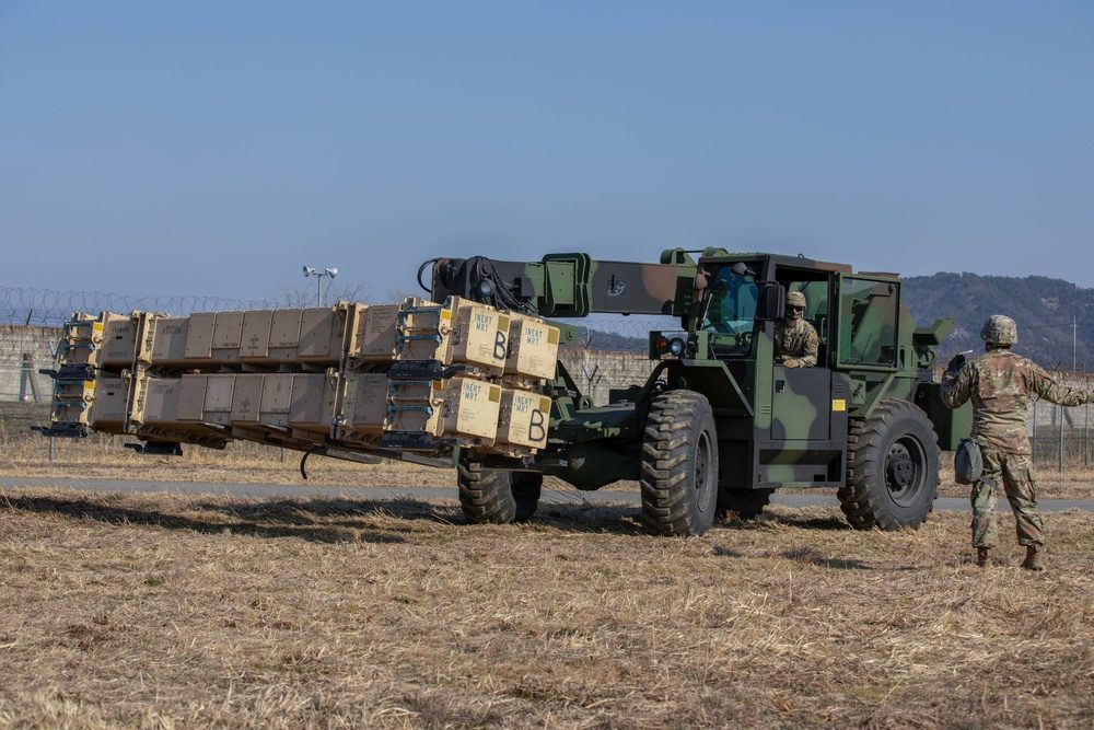 Patriot missile canisters being positioned by forklift at a firing battery