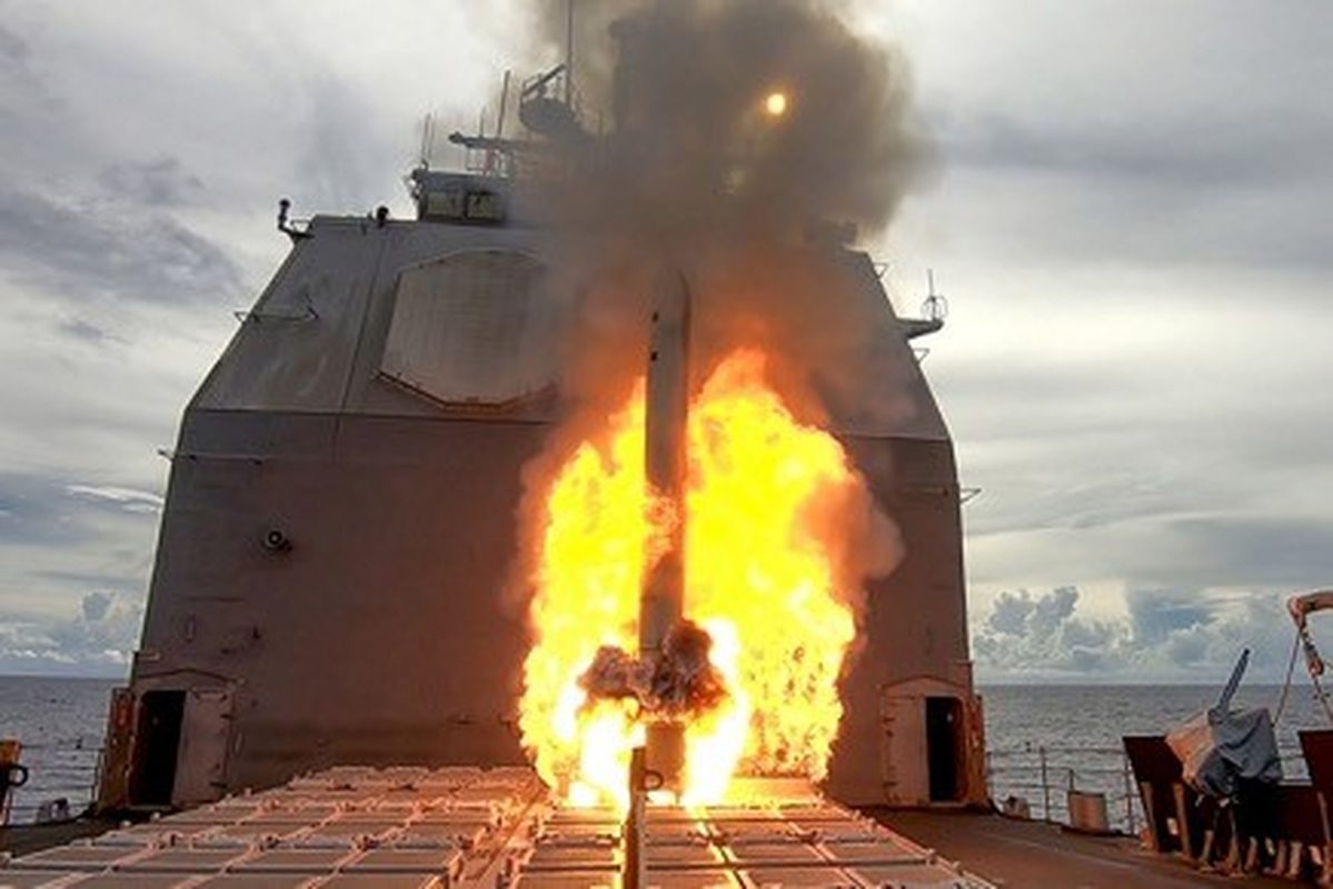 Tomahawk cruise missile launching from a ship's vertical launch system with exhaust plume visible