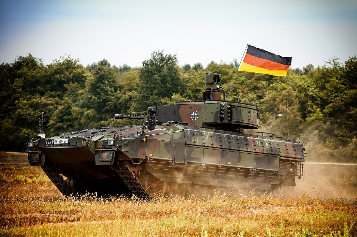 Puma IFV advancing through a field with German flag and dust cloud
