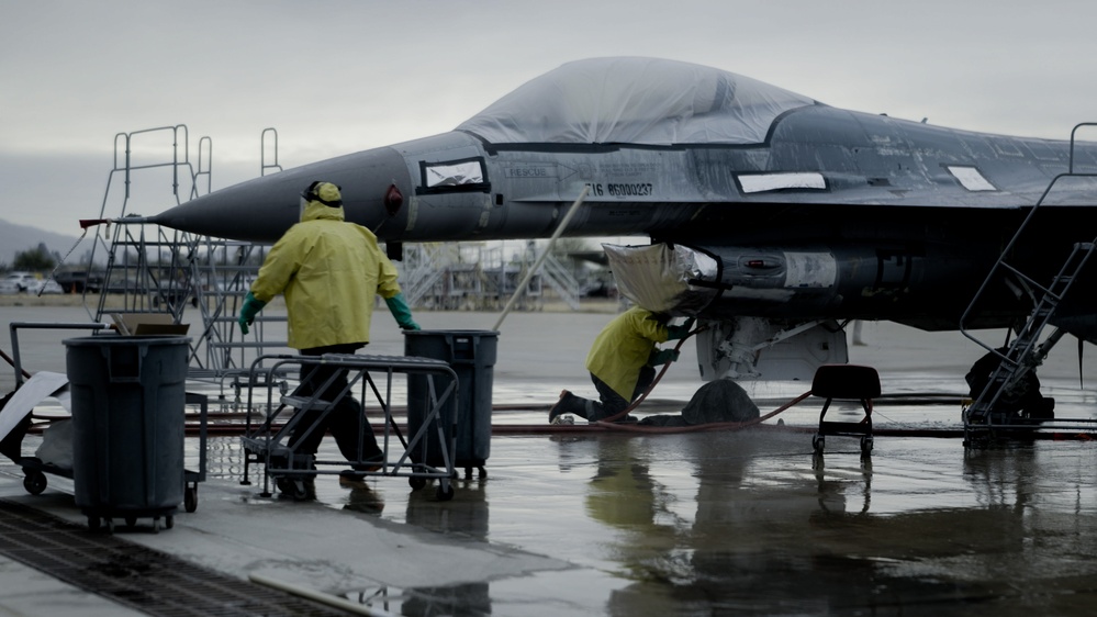 Employees clean an F-16 Fighting Falcon at the 309th Aerospace Maintenance and Regeneration Group