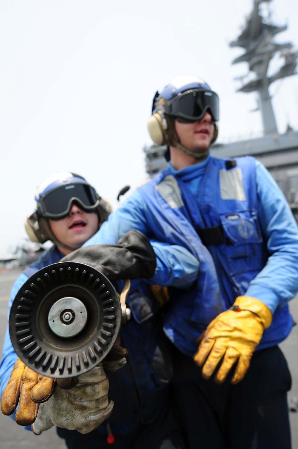 Flight deck crew conduct safety drills on an aircraft carrier