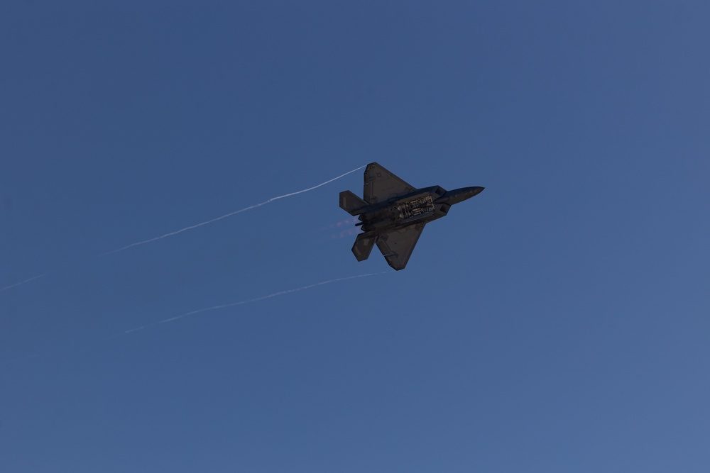 F-22 Raptor releasing a flare during a nighttime airshow demonstration showcasing the aircraft's stealth profile