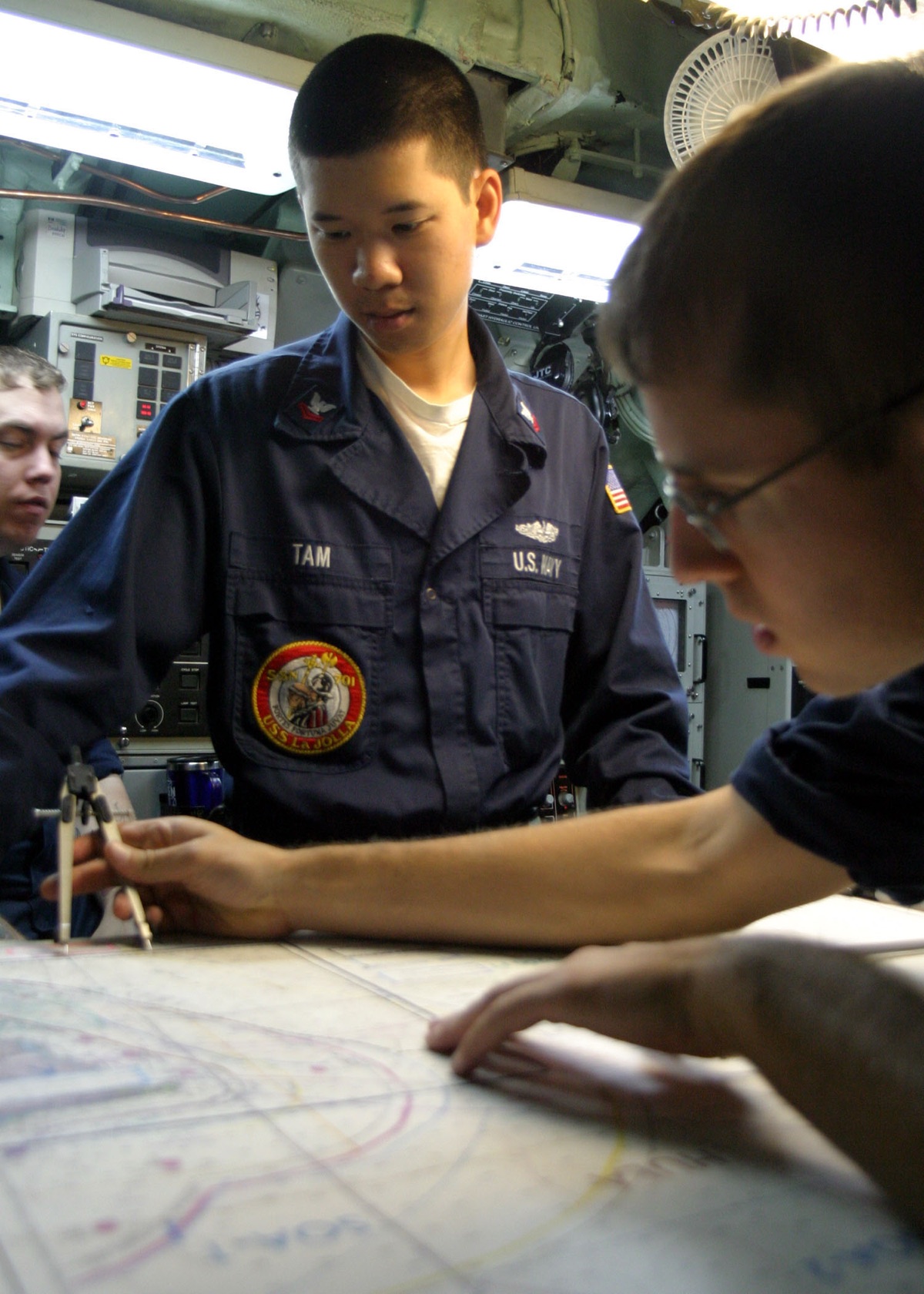 U.S. Navy sailors manning stations in a submarine control room during operations