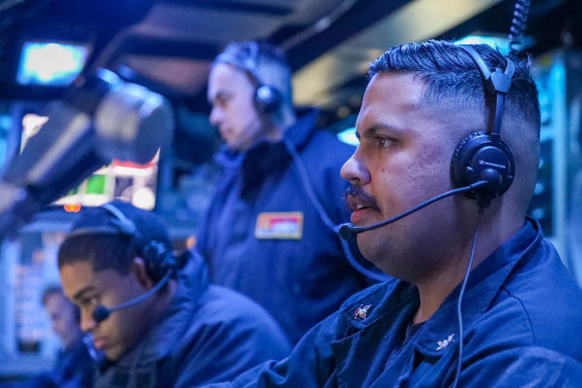 Sonar technician monitoring displays in the main sonar room aboard a guided-missile destroyer during anti-submarine warfare exercise