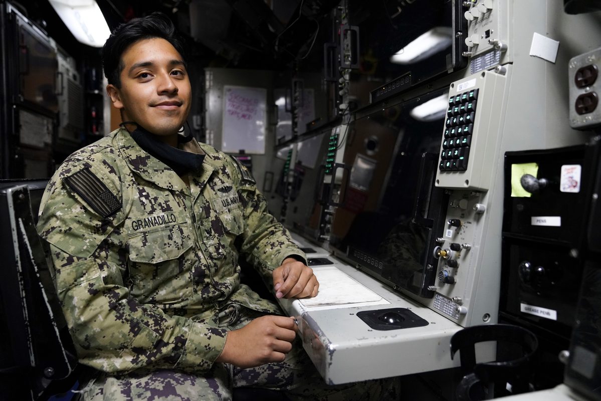 Sonar technician aboard a Los Angeles-class fast-attack submarine seated at sonar station with display equipment