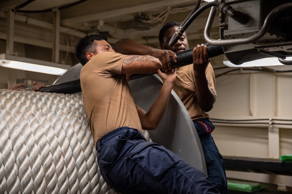 Sailors deploying a multi-functional towed array sonar from the stern of a Navy destroyer in the Mediterranean Sea