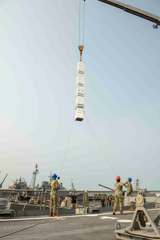 Sailors loading a Tomahawk missile canister into Mark 41 vertical launch system cells