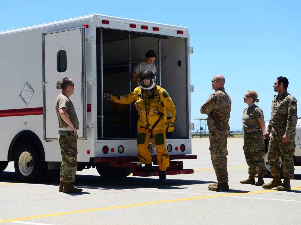 U-2 pilot in yellow pressure suit stepping from transport van with support crew