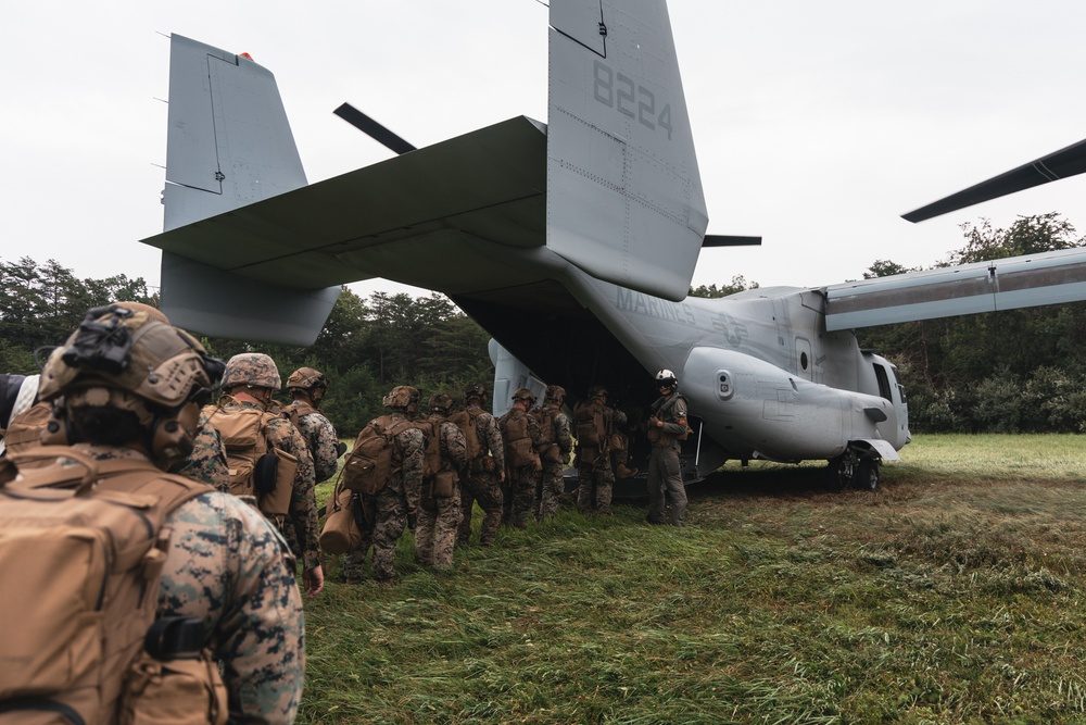 U.S. Marines boarding an MV-22 Osprey at a military base preparing for a training mission