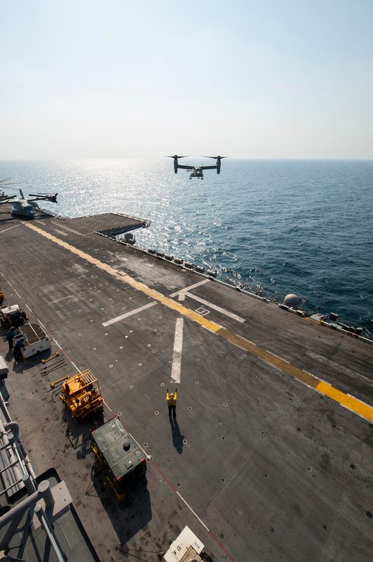 MV-22 Osprey approaching the flight deck of USS America amphibious assault ship with rotors in helicopter mode